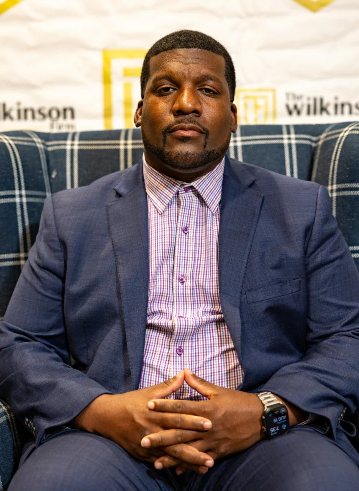 Daryan Wilkinson, Founder & CEO of The Wilkinson Firm, seated